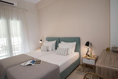 ein Schlafzimmer mit einem großen Bett mit einem Buch darauf in der Unterkunft Hellona house ,sunny and cozy apartment's in Nafplio