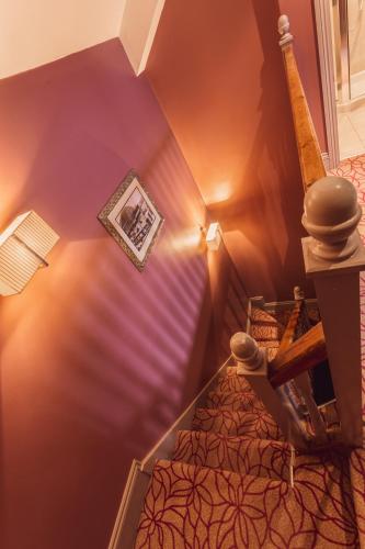 an attic room with purple walls and a picture on the wall at The Gardens Hotel in Manchester