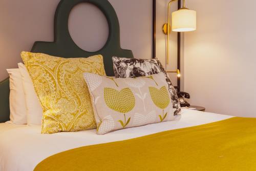 a bed with two pillows on top of it with at The Gardens Hotel in Manchester