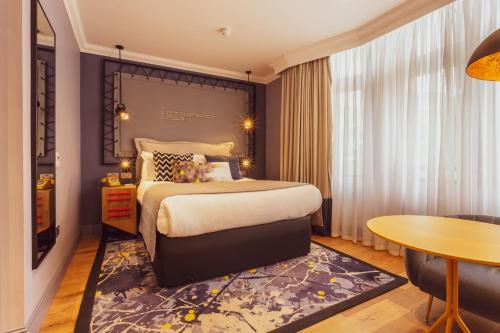 a hotel room with a bed and a table at The Gardens Hotel in Manchester