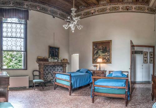 ティエーネにあるCastello di Thieneのベッド2台とシャンデリアが備わる客室です。