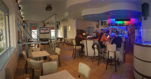 a restaurant with people sitting at a bar at The Portland Hotel in Folkestone