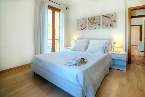 ein weißes Bett mit einem Teller Essen darüber in der Unterkunft Casa Il Glicine a due passi dal centro in Siena
