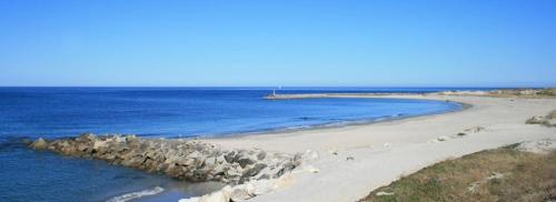 a beach with rocks and the ocean on a sunny day at Quintinha do Periqueiro in Castelo do Neiva