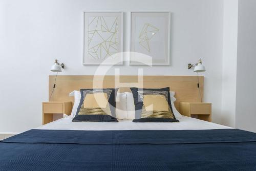 a bedroom with a blue and white bed with two lights at The Gallery by Clifton Homes in Accra