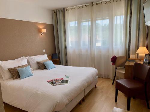 una habitación de hotel con una cama con un libro encima en Brun, en Saint-Lattier