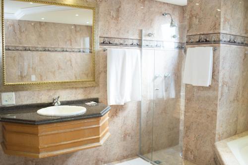 a bathroom with a sink and a shower at Rihad Palace Hotel in Araucária