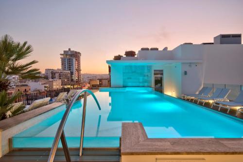 a swimming pool on the roof of a building at Hotel Valentina in St Julian's