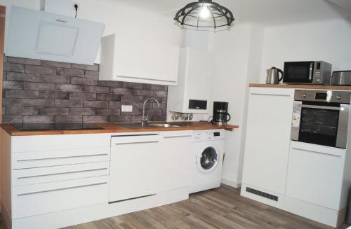 a kitchen with white cabinets and a washer and dryer at Ferienwohnung Auszeit in Bad Kreuznach