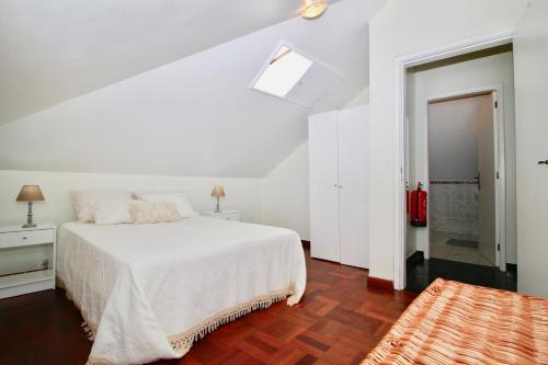a white bedroom with a bed and a bathroom at Casa Maria in Funchal