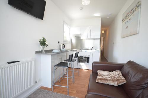 a living room with a couch and a kitchen at Lake Lodges in Chichester