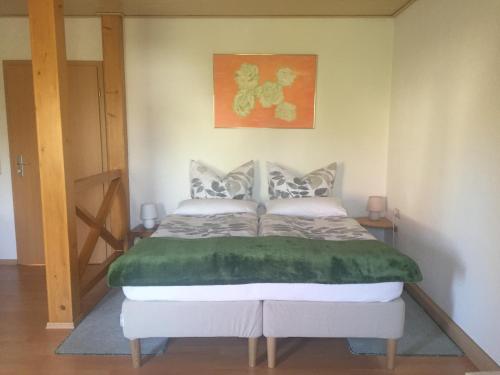 um quarto com uma cama com um cobertor verde em Pension Jahn em Senftenberg