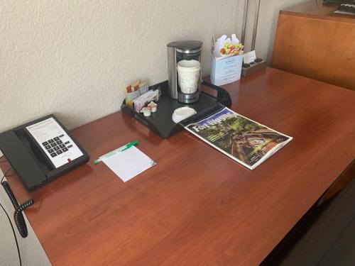 a desk with a coffee maker and a phone on it at Wyndham Garden Fort Wayne in Fort Wayne