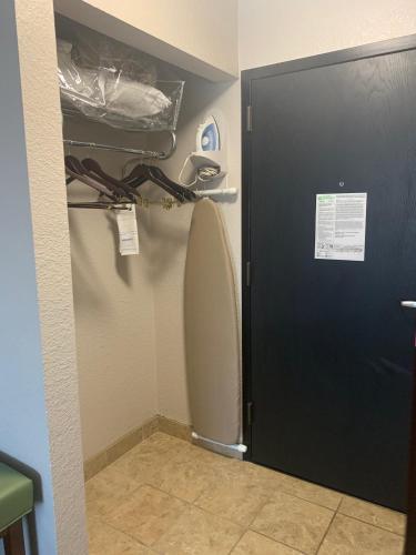 a bathroom with a toilet and a black door at Wyndham Garden Fort Wayne in Fort Wayne