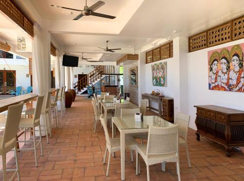 a restaurant with tables and chairs and a ceiling fan at Oslob Whale Shark Resort in Oslob