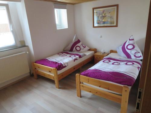 2 Einzelbetten in einem Zimmer mit 2 Fenstern in der Unterkunft Ferienwohnung Schloßberg in Pretzfeld