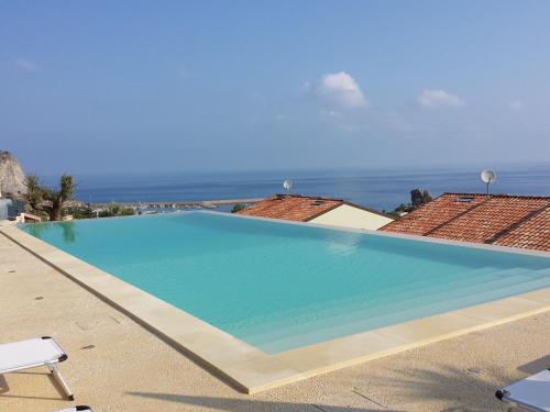 a large swimming pool with the ocean in the background at Residence Magarà in Cefalù