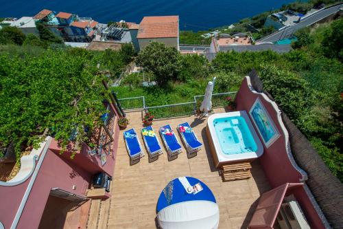 a group of chairs and a swimming pool on a building at Palazzo Rocco Villa Sunshining in Love in Praiano