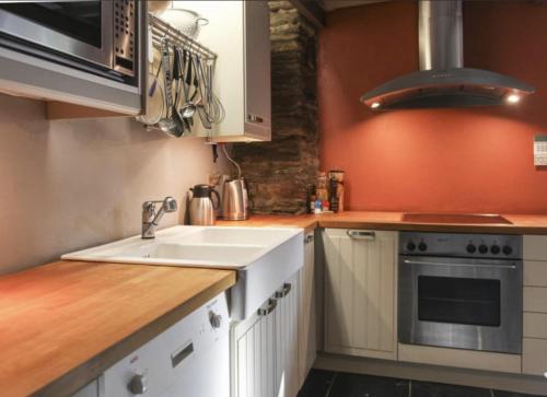 a kitchen with a sink and a stove at Cosy Authentic Farmhouse - LaComte5 in Vielsalm