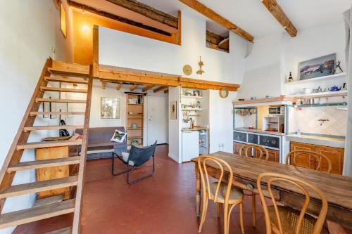 une cuisine et une salle à manger avec une table et des chaises en bois dans l'établissement Le Central par Dodo-a-Cassis, à Cassis