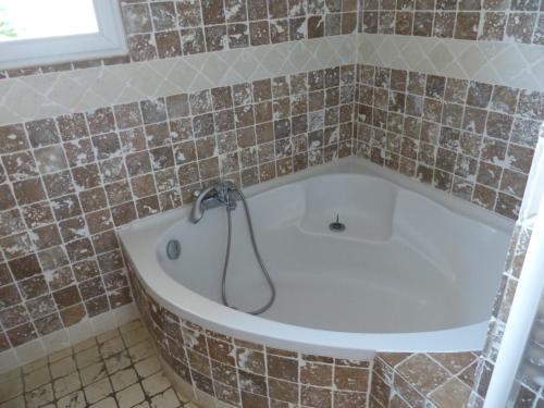 La salle de bains carrelée est pourvue d'une baignoire et d'une douche. dans l'établissement BAVELA, à Porto-Vecchio