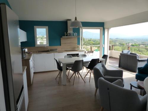 une cuisine et une salle à manger avec une table et des chaises dans l'établissement BAVELA, à Porto-Vecchio