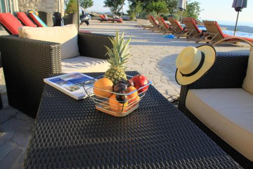 a basket of fruit on a table with a hat at Villa Eagle Eye Montenegro in Kotor