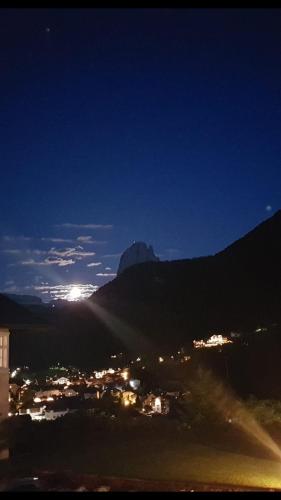 a view of a city at night with a mountain at Hotel Villa Emilia in Ortisei
