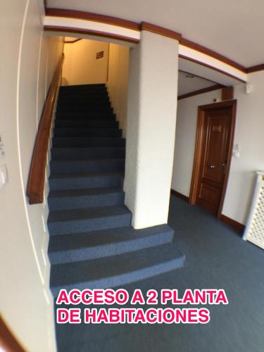 a stairway in a building with blue stairs at Hostal Vista Alegre in Castro-Urdiales