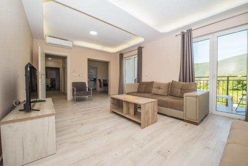 a living room with a couch and a tv at Apartment Vrutak in Kotor