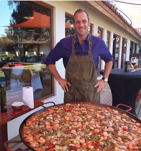 a man in an apron standing next to a large pizza at Hotel Boutique BC Wine Casablanca in Casablanca
