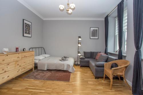 a living room with a bed and a couch at CR Apartament w Śródmieściu Sienkiewicza 1 in Białystok