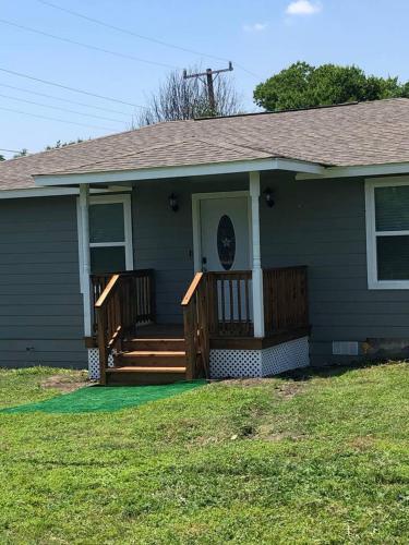 a green house with a porch with a wooden deck at Downtown Contemporary yet Cozy Fun in San Antonio
