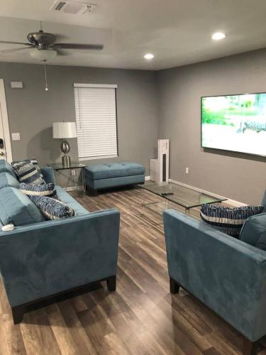 a living room with blue couches and a flat screen tv at Downtown Contemporary yet Cozy Fun in San Antonio