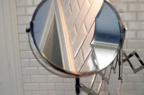 a mirror hanging on a wall in a bathroom at Atlas B&B in Ghent