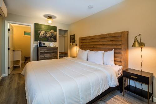 una camera da letto con un grande letto bianco con testiera in legno di Cottages On River Road a Guerneville