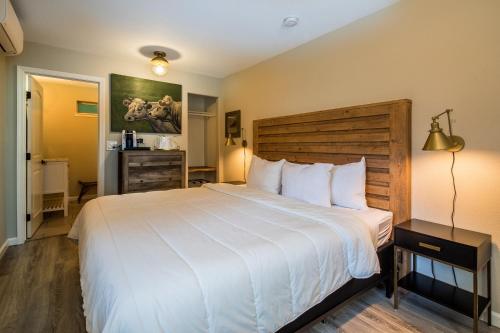 um quarto com uma grande cama branca e uma cabeceira em madeira em Cottages On River Road em Guerneville