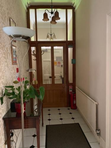 a hallway with a door and a plant in front of it at Green Gables Guest House in Chester