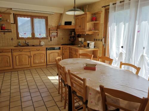 cocina con mesa de madera, sillas, mesa y mesa en Chalet les Lurins, en Villarlurin