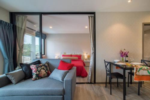 a living room with a couch and a bedroom at The Title Residencies Naiyang by Beringela in Nai Yang Beach