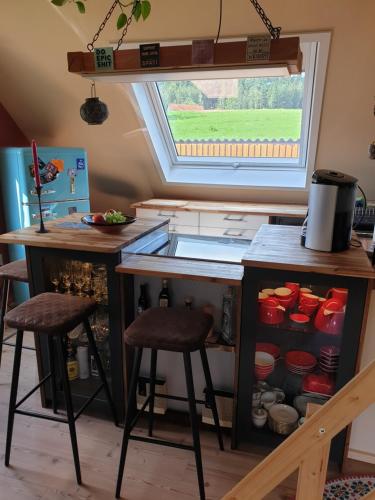 a kitchen with a sink and a counter with stools at Ferienwohnung im Grünen in Gschwend