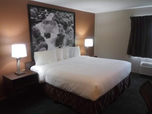 a large bed in a hotel room with two lamps at Super 8 by Wyndham Lynnwood in Lynnwood