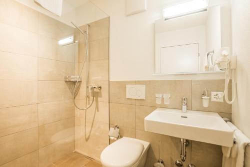 a bathroom with a toilet and a sink and a shower at Berghotel Schonhalden in Flums