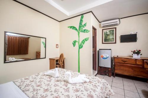 a bedroom with a bed with a swan on it at Cadillac Rock Beach Hotel in Jacó