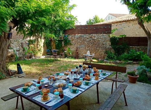 uma mesa com comida num jardim em Chez Lola-Maison d'hôtes Corbières em Durban-Corbières