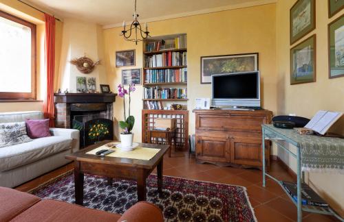 a living room with a couch and a tv at Fontanaro Farm and Culinary School in Paciano