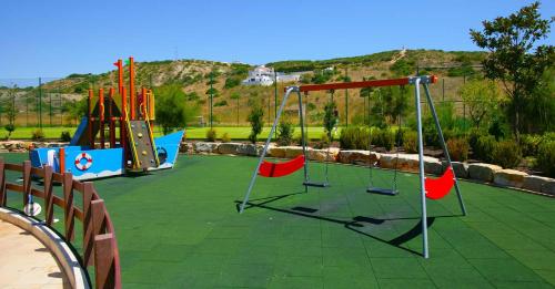 a playground with a swing set and a slide at Luz Beach Luxury Apartment in Luz