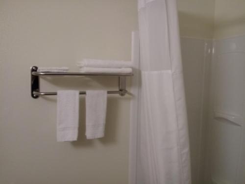 łazienka z zasłoną prysznicową i ręcznikami w obiekcie Super 8 by Wyndham Lynnwood w mieście Lynnwood