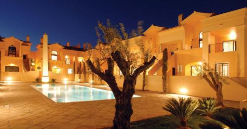 a villa with a swimming pool at night at Luz Beach Luxury Apartment in Luz