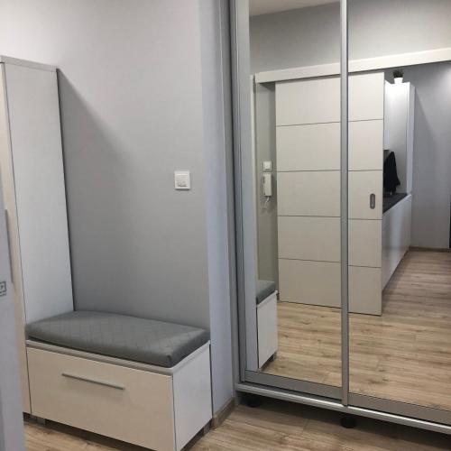 a room with a mirror and a chair in a room at Klimatyzowany Apartament ROMA z garażem podziemnym in Kielce